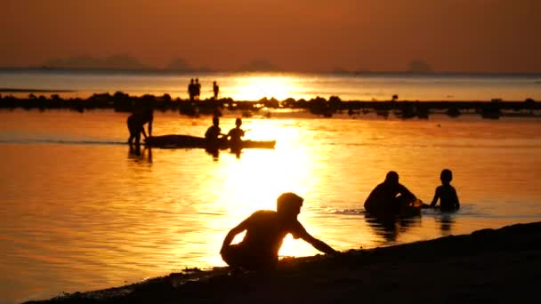 Kinderen spelen bij zonsondergang. Zee kust, warme kleuren — Stockvideo