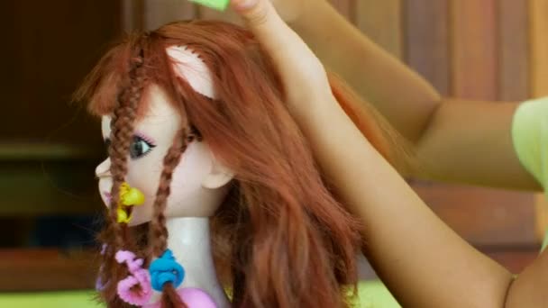 Mädchen im Vorschulalter macht Frisurpuppe. Heimspiele beim Friseur — Stockvideo