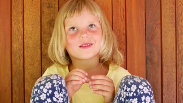 Niña preescolar mirando a la cámara y sonriendo — Vídeos de Stock