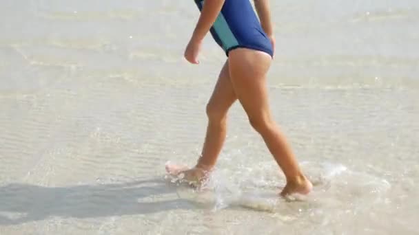 Шестилетняя девочка бежит вдаль на мелководье. Море — стоковое видео