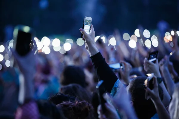 Music fan filming concert with smart phone in hand — Stock Photo, Image