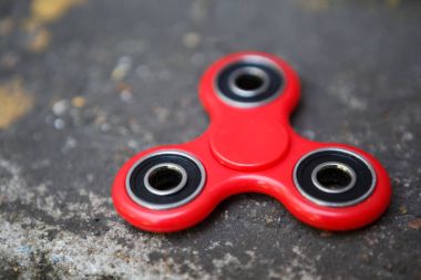 Kırmızı topluca spinner oyuncak. İplik aygıt yatakları ile