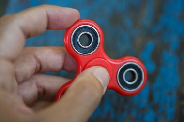 Kırmızı topluca spinner oyuncak. İplik aygıt yatakları ile