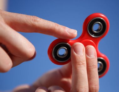 Red fidget spinner toy.Spinning device with bearings clipart