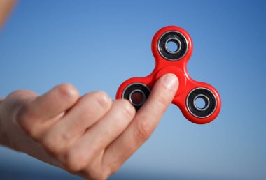 Kırmızı topluca spinner oyuncak. İplik aygıt yatakları ile