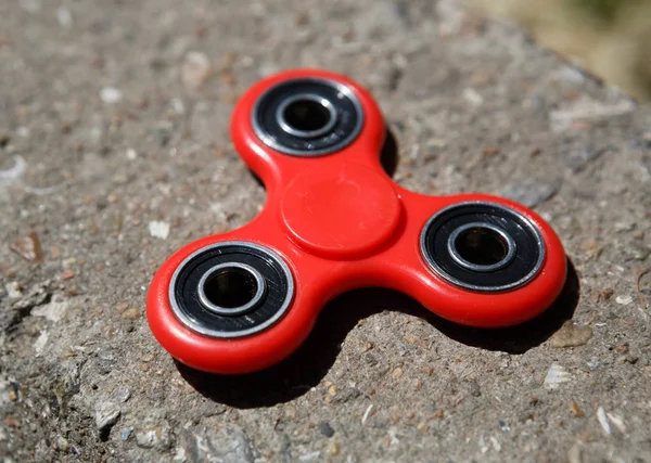 Kırmızı topluca spinner oyuncak. İplik aygıt yatakları ile