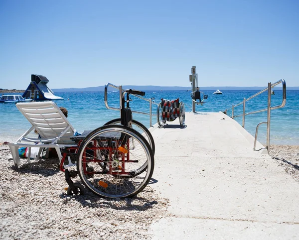 Инвалидное кресло на пляже для инвалидов — стоковое фото