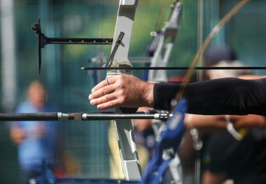 Profesyonel okçulardan oluşan bir grup modern yay ile hedefleri vuruyor. Ok tutan atletlere odaklan. Açık havada Olimpiyat okçusu müsabakası