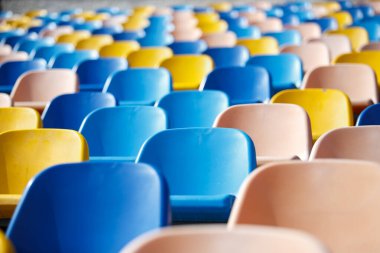 Güneşli bir günde açık hava spor salonu koltukları. Spor alanında boş fan alanı. Futbol hayranları için plastik tribünler. 