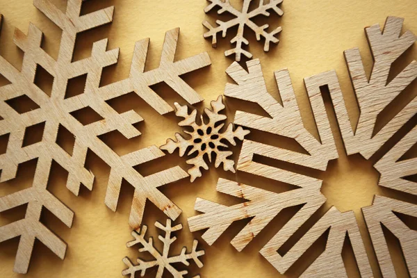 黄色の背景に手作りの雪のフレーク 冬の休日に家の装飾のために木からカット手作りの雪のフレークのフィギュア — ストック写真