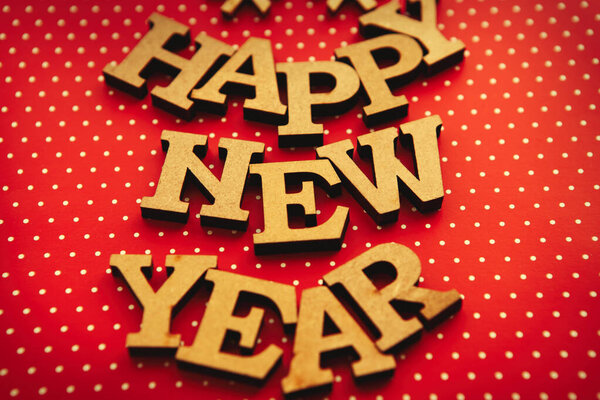Rustic wooden letters for Happy New Year celebration.Red paper background with hand made alphabet for winter holidays celebration
