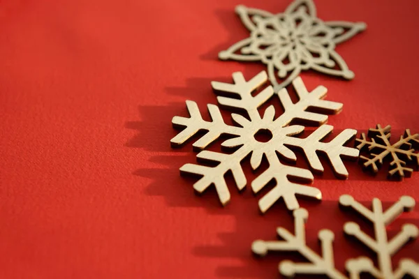 大晦日と新年のお祝いのための手作り工芸品 赤い背景に木製の雪のフレークを手作り — ストック写真