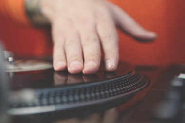 Hip hop DJ 'i müzikle plak plaklarını çiziyor. Profesyonel disk jokeyi, gece kulübünde klasik dönüm tablosu kaydedicisi ile müzik parçaları çalıyor. Konser, müzik ekipmanlarını yakın çekimde çalıyor.