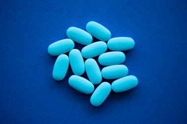 Düz katmanlı mavi tıbbi haplar. Vitamin ilaçları ya da gıda takviyeleri yakın planda. Hastalığı ilaç tabletleriyle tedavi edin.