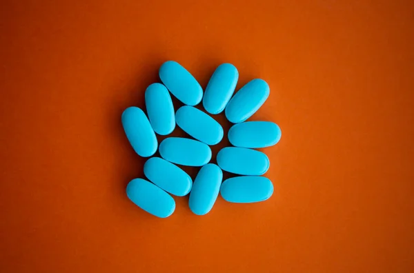 扁平的蓝色药丸放在空的桔子背上 近视的维生素药物或食品补充剂 有药桌的治愈疾病 治疗健康和健康的化学疗法 — 图库照片