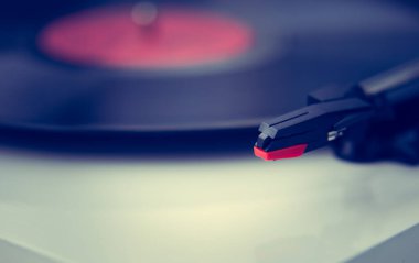 Klasik turntable iğnesi ve analog vinil plağı yakından. Retro tarzı ses donanımı. Trun tablosu oynatıcı aygıtıyla yüksek kaliteli müzik parçalarını dinleyin.