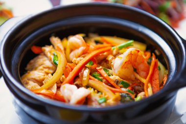 Güveçte Asya deniz ürünleri. Kaynamış karidesli lezzetli jambalaya tarifi, tavuk eti ve taze sebzeler. Vietnam mutfağıyla korunaklı doğal deniz ürünleri. 