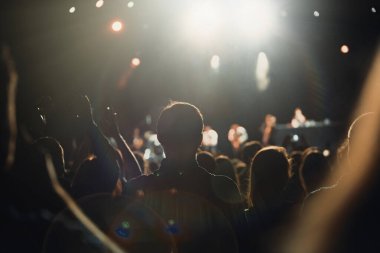 Müzik hayranları gece kulübünde gösterinin keyfini çıkarıyor. Parlak DJ konser sahnesi mavi ışıklandırma. Büyük bir grup insan en sevdiği şarkıyı dinliyor.