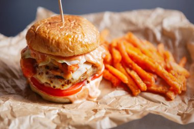 Fast food teslimatı. Kahverengi kağıtta çizburger ve havuç kızartması. Lezzetli fast food menüsü.