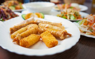 Vietnam restoranında servis edilen karidesli yumurtalı börekler. Masada lezzetli Asya deniz yemekleri. Cripsy pirinç kağıdına sarılmış egzotik karides serpintilerinin tadını çıkarın.