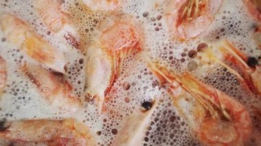 Mutfakta sıcak suda karidesler kaynıyor. Şef paella için karides pişiriyor. Restoranda egzotik Akdeniz yemekleri için deniz ürünleri pişiriliyor.