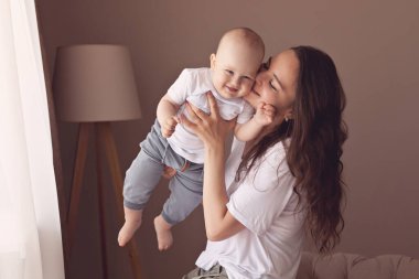 Genç bir anne ve bir yaşındaki oğlunun evdeki portresi.