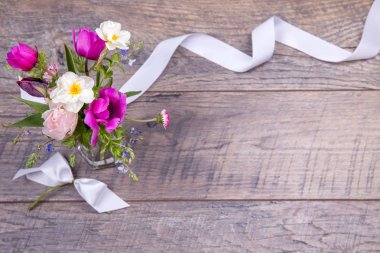 Beyaz ahşap arka planda şenlikli çiçek kompozisyonu. Genel Görünüm.