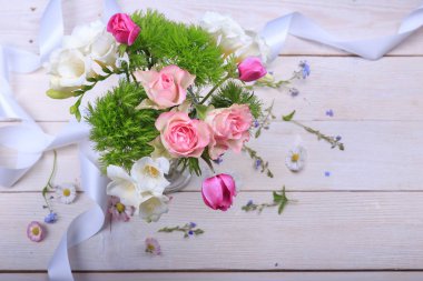 Beyaz ahşap arka planda şenlikli çiçek kompozisyonu. Genel Görünüm.