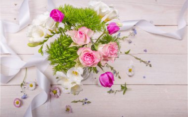 Beyaz ahşap arka planda şenlikli çiçek kompozisyonu. Genel Görünüm.