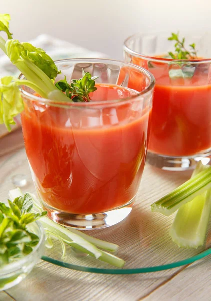 Two glasses of fresh tomato juice with thyme and celery. — Stock Photo, Image