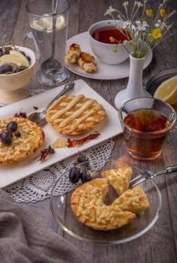 Kahvaltı için iki, limon tarte ve ahşap masa üzerinde çay