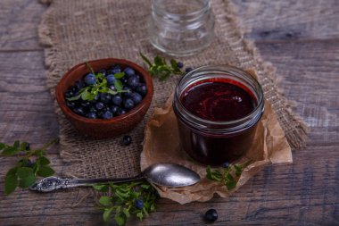 Böğürtlenli reçel çilek ve yaprakları rustik ahşap masa üzerinde kavanoza