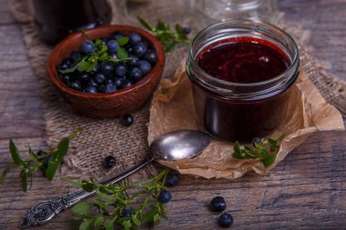 Böğürtlenli reçel çilek ve yaprakları rustik ahşap masa üzerinde kavanoza