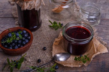 Böğürtlenli reçel çilek ve yaprakları rustik ahşap masa üzerinde kavanoza