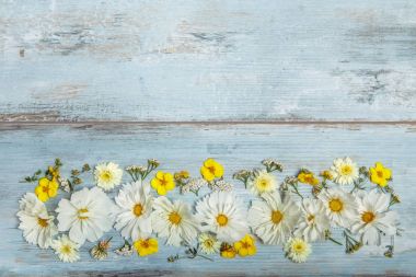 Bir buket beyaz çiçekler cosmea veya evren mavi kurullarında. El yapımı ahşap masa arka plan üzerinde Bahçe sarı çiçekler. Zemin kopya alanı ile.