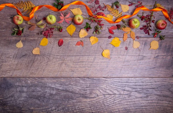 Arreglo otoñal de hojas, manzanas y bayas sobre un fondo de madera con espacio libre para texto. Vista superior, concepto de la temporada — Foto de Stock