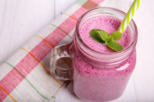Berry milkshake veya malzemeler ile güler yüzlü. Mason kavanoza sağlıklı içecek.