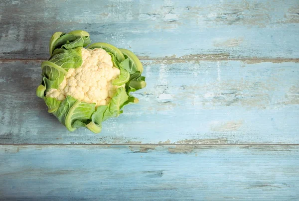 Coliflor sobre un fondo rústico de madera azul. Alimentación saludable, concepto vegetariano . —  Fotos de Stock