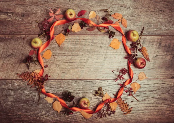 Arreglo otoñal de hojas, manzanas y bayas sobre un fondo de madera con espacio libre para texto. Vista superior, concepto de la temporada — Foto de Stock