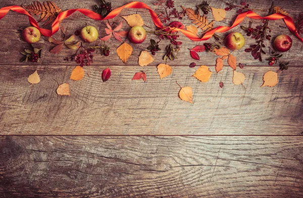 Arreglo otoñal de hojas, manzanas y bayas sobre un fondo de madera con espacio libre para texto. Vista superior, concepto de la temporada — Foto de Stock