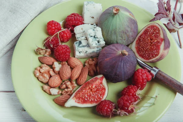 Slouží tabulka, čerstvé fíky, ovoce, plody, sýr a ořechy na bílém pozadí dřevěná — Stock fotografie