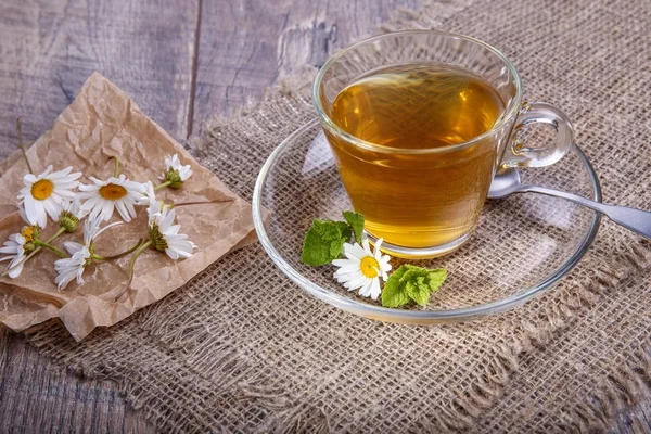 Une tasse de thé à la camomille sur fond de bois. Médecine alternative, traditionnelle — Photo