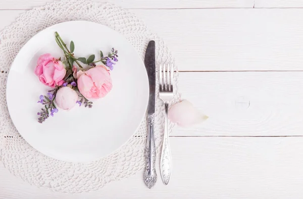 Mesa festiva con cubiertos, pequeña rosa y corazones sobre mesa rosa. Vista superior . — Foto de Stock