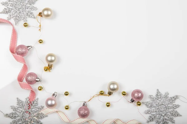 Composición navideña. Ramas de abeto, árbol de Navidad, bola de fiesta de decoración rosa de Navidad con cinta sobre fondo blanco. — Foto de Stock