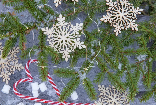 Різдвяний фон з ялиновими гілками, прикрашені сніжинки та цукерки на льоду в вінтажному стилі — стокове фото