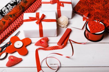 Beyaz kağıt ve kırmızı kurdele, Kalpler, mumlar ve şenlikli hediye Sevgililer günü, Noel, yeni yıl veya doğum günü için ambalaj için bir çalışma yüzeyi sarılmış hediye kutuları.