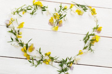 Çiçek kompozisyon. Çerçeve sarı kır çiçekleri beyaz arka plan üzerinde bir kalp şeklinde yapılmış. Düz yatıyordu, en iyi görünüm. Uzay kopyalayın. Doğum günü, anne, Sevgililer, kadın, düğün günü kavramı.