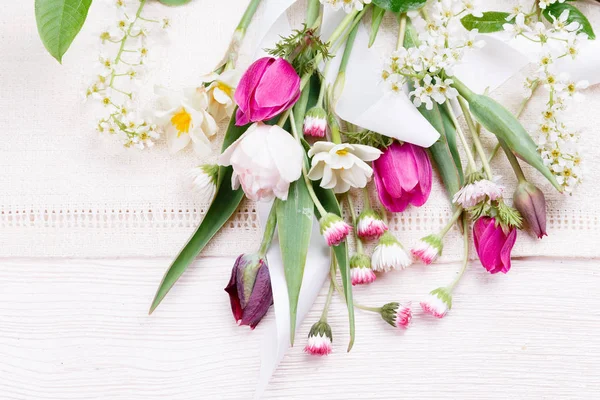 Ramillete de flores primaverales, tulipanes rosa, púrpura, narcisos y margaritas sobre fondo de madera blanca . —  Fotos de Stock