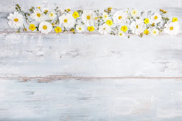 A bouquet of white flowers cosmea or cosmos with ribbon on white boards. Garden yellow flowers over handmade wooden table background. Backdrop with copy space. — Stock Photo, Image