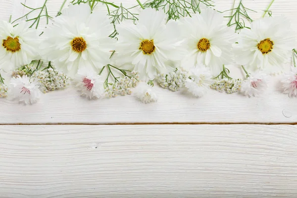 흰색 꽃 cosmea 또는 화이트 보드에 리본으로 코스모스의 꽃다발. 수 제 나무 테이블 배경 위에 정원 노란 꽃입니다. 배경 복사 공간. — 스톡 사진